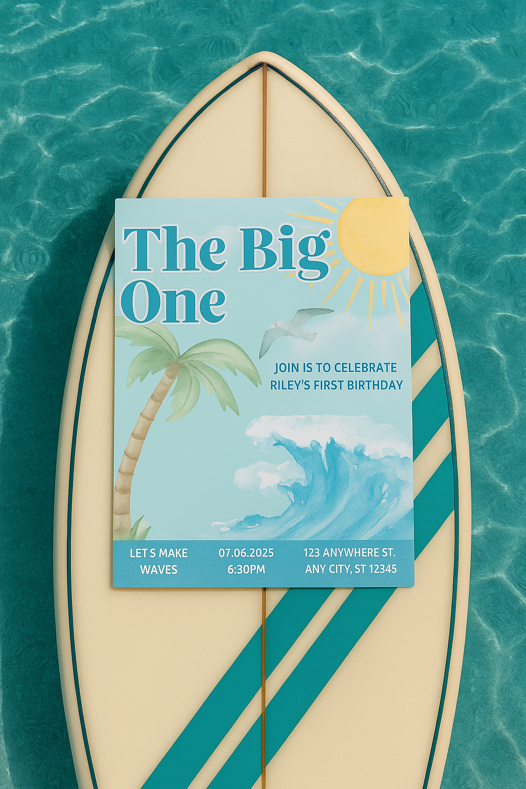 Overhead flat lay of a tropical first birthday invitation titled "The Big One," displayed on a pastel surfboard floating in clear blue water. The invite features palm trees, a crashing wave, and a playful seagull, surrounded by seashells, tropical flowers, and subtle reflections from the water’s surface. The summery scene captures a fun, beachy vibe perfect for a surf-themed celebration.