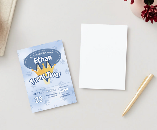 Flat lay of a Bluey-inspired birthday invitation for “Ethan Turns Two!” placed on a neutral surface with a blank white card, gold pen, and flower vase. The invite features a crown, paw prints, and event details for August 23 at 11:00 AM with RSVP info.